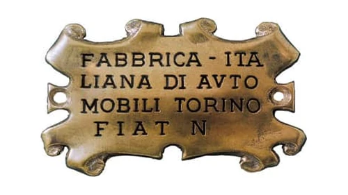 Первый логотип Fiat 1899 года: латунная табличка в виде пергамента с выгравированным полным названием компании