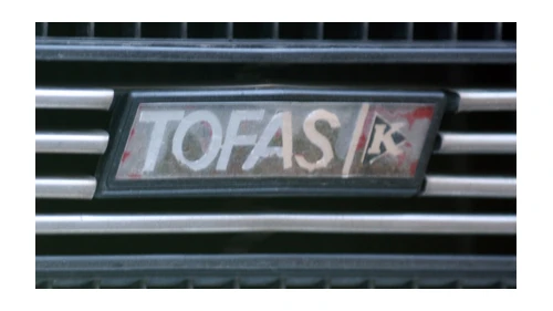 Логотип Tofaş около 1976 года: значок TOFAŞ на решётке со знаком K